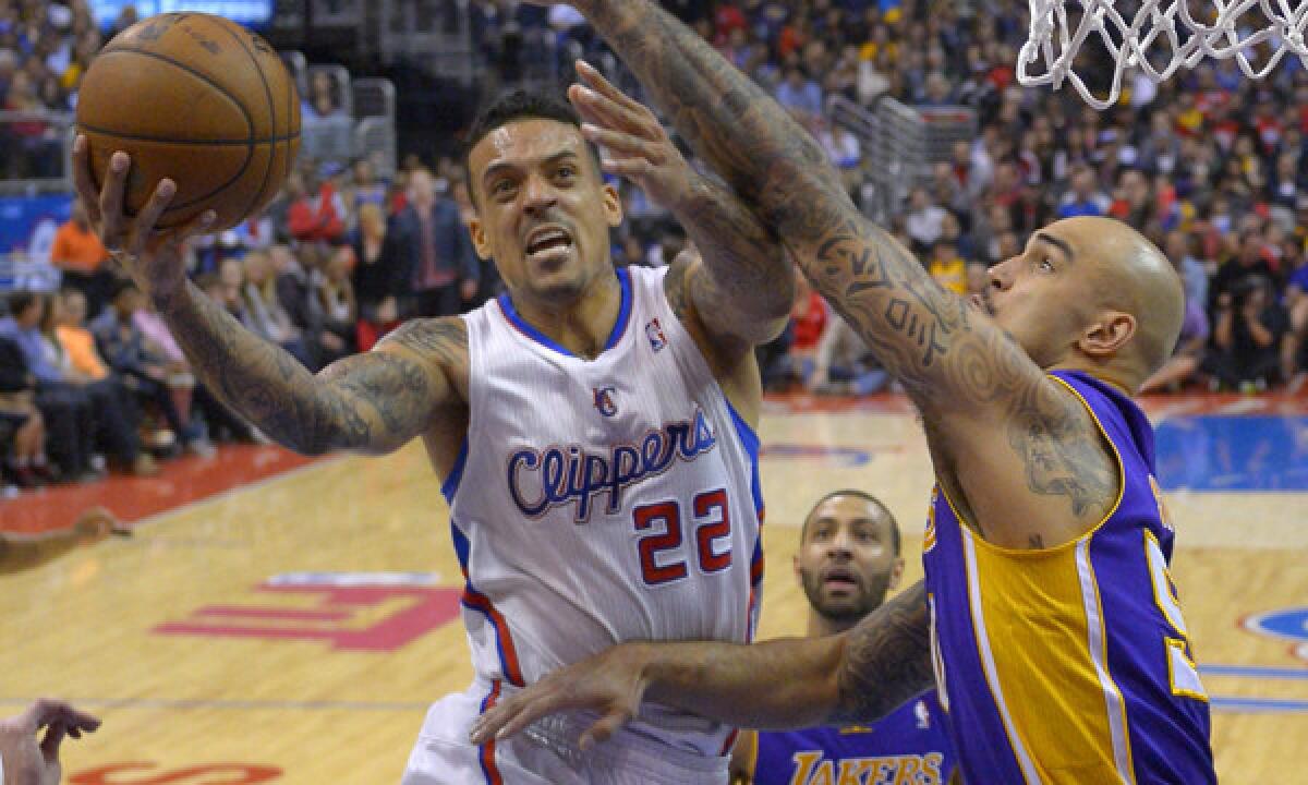 Clippers small forward Matt Barnes, left, puts up a shot in front of Lakers center Robert Sacre during the Clippers' 123-87 win on Jan. 10.