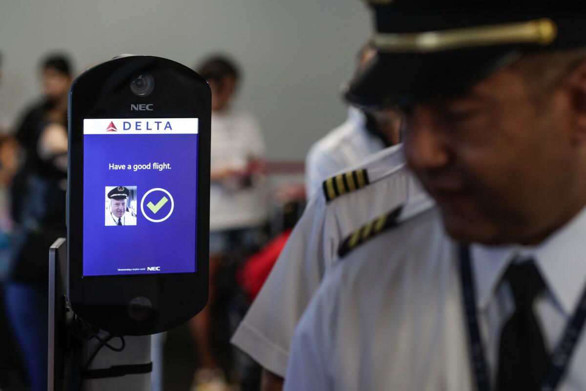 Airline crew members file past an airport biometric system.