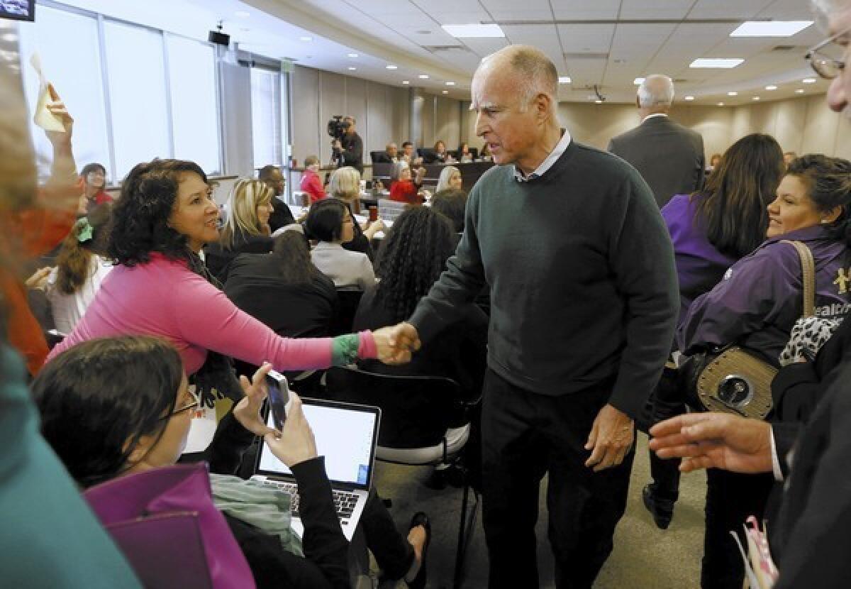 Gov. Jerry Brown shakes hands with a member of the audience as he leaves the state Board of Education meeting in Sacramento on Thursday. Brown has been traveling widely throughout the state recently, laying out a case for his reelection, although he has not formally announced his candidacy.