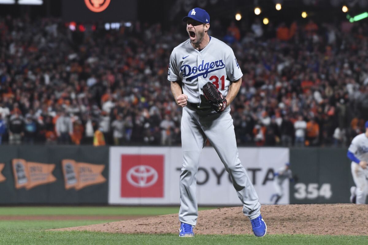 Dodgers starting pitcher Max Scherzer reacts after striking out San Francisco Giants' Wilmer Flores on Oct. 14, 2021.