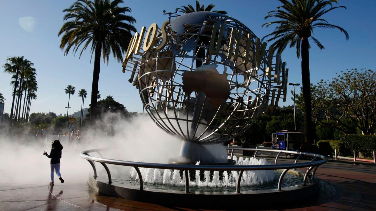 Pammy Hamm, 6, runs around the entrance to Universal Studios Hollywood before it opens on March 14, 2013. The theme park raised the cost of a peak-demand daily ticket over the weekend from $120 to $129 but offers discounts with online purchases.