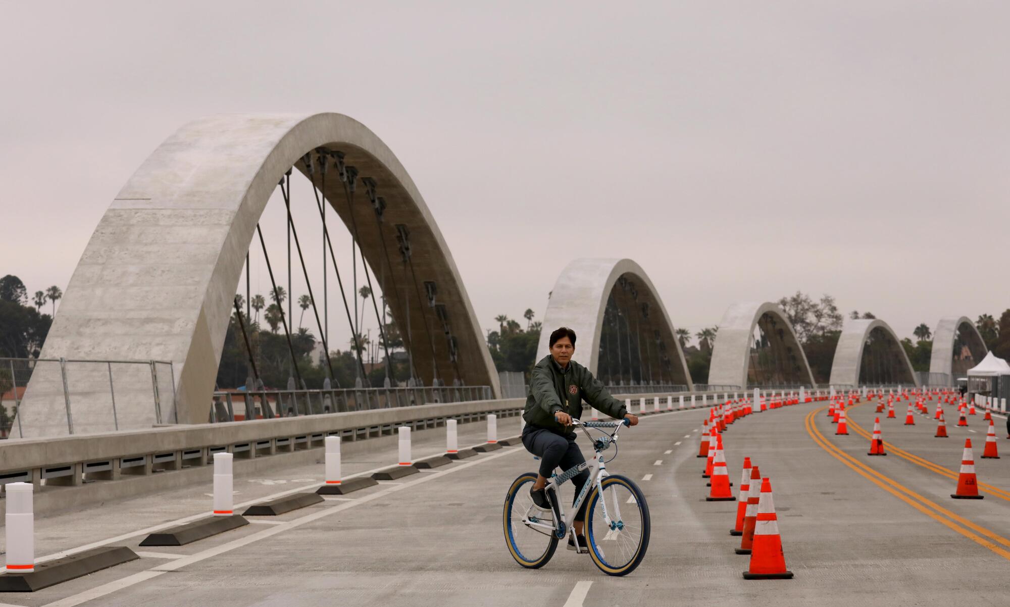 Los Angeles City Councilman Kevin de León rides a bike on the new 6th Street Viaduct.