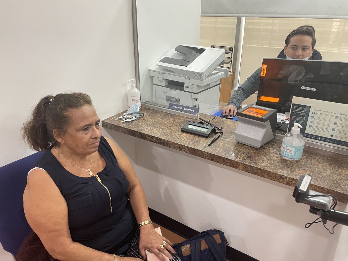 Un empleado del consulado de El Salvador le realiza la captura de datos biométricos a la usuaria Ana Tránsito Peñate.