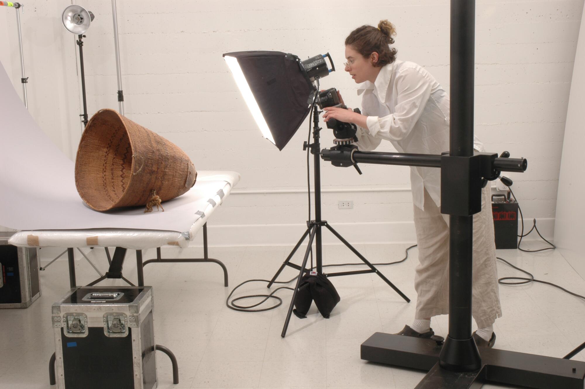 A woman takes a photo of a woven basket