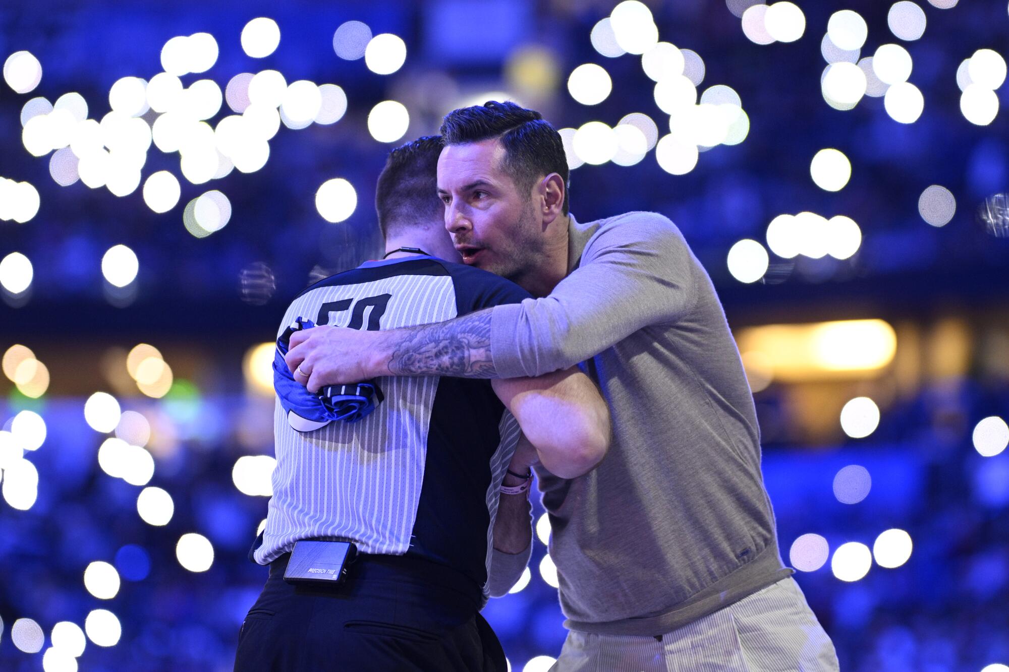 Former Magic guard JJ Redick, right, and official Gediminas Petraitis greet each other on the court during a game in Orlando.