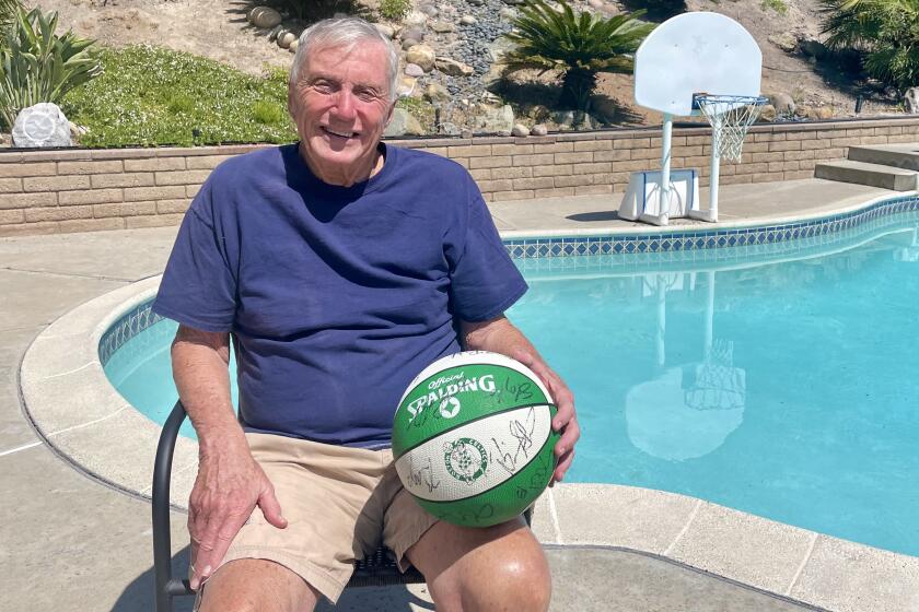 Former NBA coach Don Casey is shown with an autographed ball from the Boston Celtics. Players from the Celtics chipped in to help pay for the pool at his Fletcher Hills home.