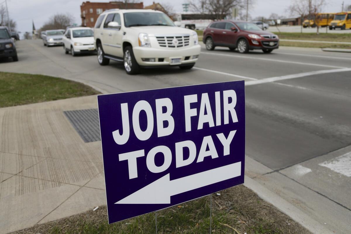A sign points to an April 10 job fair on the campus of Kaplan University in Lincoln, Neb.