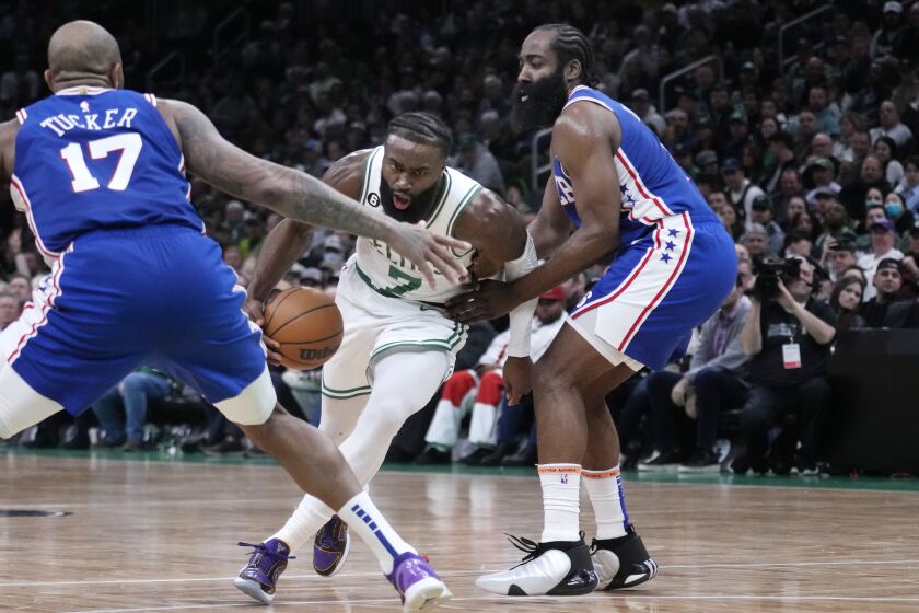 Boston Celtics guard Jaylen Brown (7) drives to the basket between Philadelphia 76ers guard James Harden, right, and forward P.J. Tucker (17) during the first half of an NBA basketball game, Wednesday, Feb. 8, 2023, in Boston. (AP Photo/Charles Krupa)