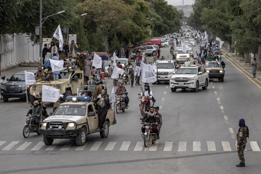 Taliban fighters celebrate with a parade one year since they seized the Afghan capital, Kabul, in front of the U.S. Embassy in Kabul, Afghanistan, Monday, Aug. 15, 2022. The Taliban marked the first-year anniversary of their takeover after the country's western-backed government fled and the Afghan military crumbled in the face of the insurgents' advance. (AP Photo/Ebrahim Noroozi)