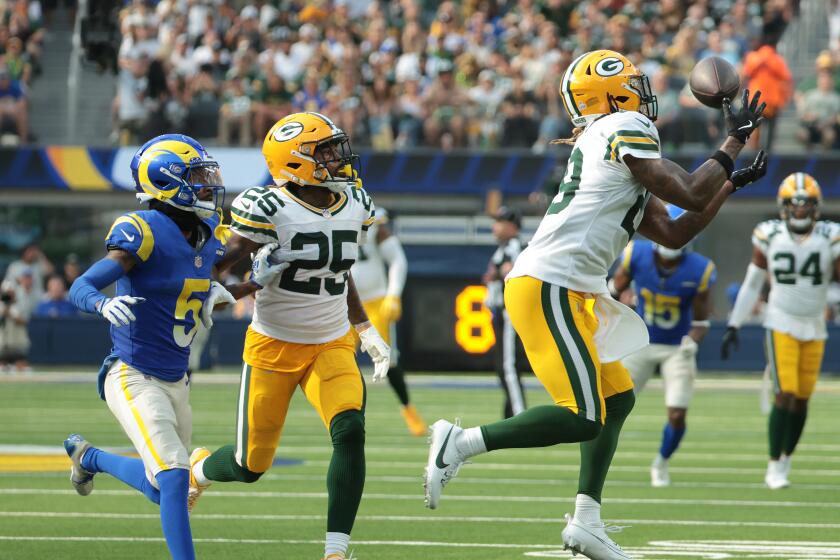 Packers safety Xavier McKinney intercepts a pass intended for the Rams' Tutu Atwell.