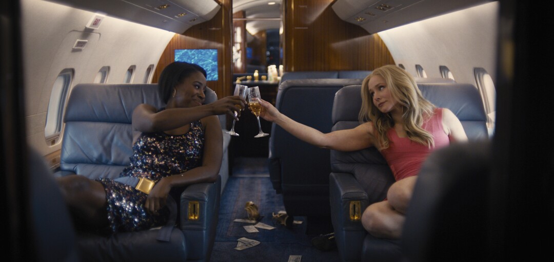 Two women toast with champagne in a private plane.