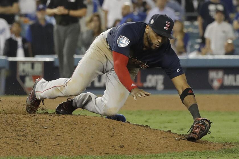 Boston Red Sox pitcher Eduardo Nunez trips on the mound after catching a pop up fly by Los Angeles Dodgers' Yasiel Puig during the 16th inning in Game 3 of the World Series baseball game on Friday, Oct. 26, 2018, in Los Angeles. (AP Photo/David J. Phillip)
