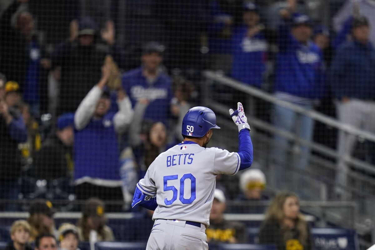Mookie Betts gestures toward Dodgers fans after hitting a solo home run in the ninth inning against the San Diego Padres.