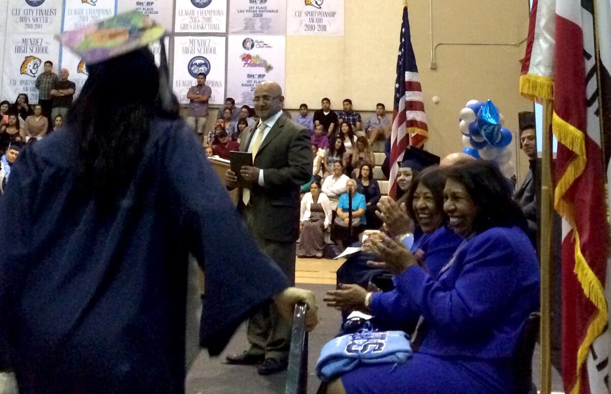 Sylvia Mendez, right, applauds graduates as they receive their diplomas at the Mendez High School graduation in June.