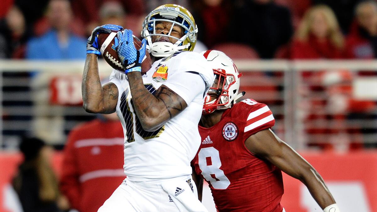 UCLA receiver Kenneth Walker III catches a 60-yard touchdown pass against Nebraska defensive back Chris Jones in the second quarter for a 14-7 lead.
