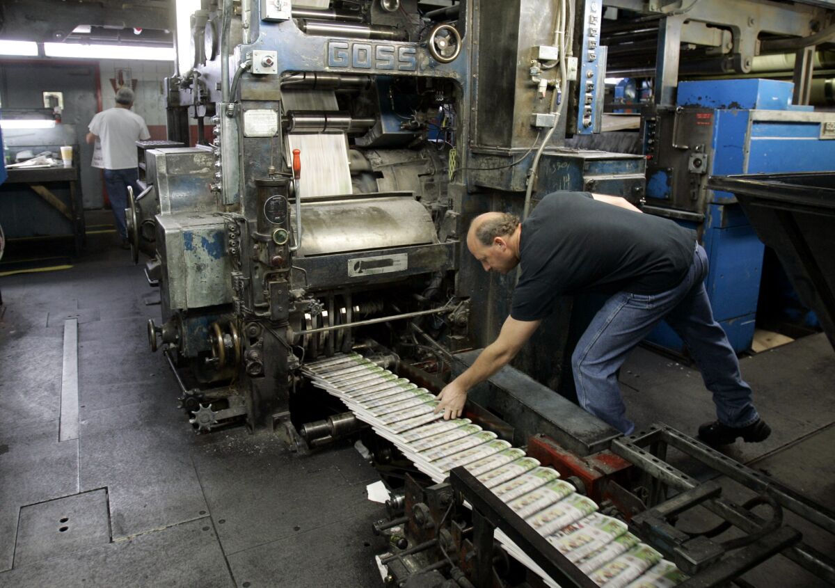 FILE - A pressman grabs a freshly printed paper off the press at the St. Louis Post-Dispatch's printing facility in Maryland Heights, Mo. in this Nov. 11, 2008 file photo. The Post-Dispatche's owner, Lee Enterprises efforts to repel a hostile takeover got a boost when a judge ruled the newspaper publisher could ignore two director nominations from the Alden Global Capital hedge fund. But Alden said it will press the fight by urging shareholders to reject two of Lee's nominees for the board. (AP Photo/Jeff Roberson, File)