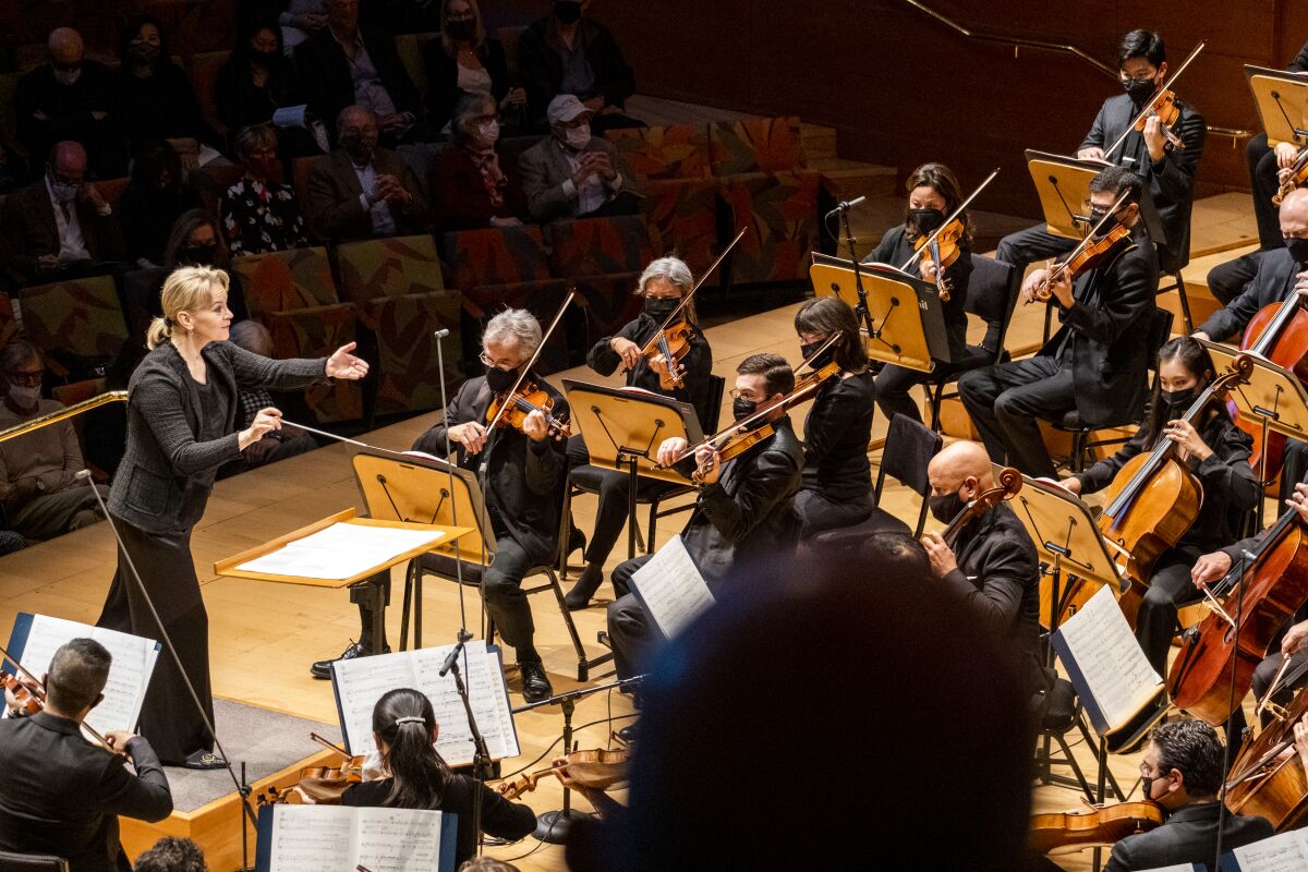 Susanna Malkki, dressed in black, is seen leading the orchestra at Walt Disney Concert Hall.