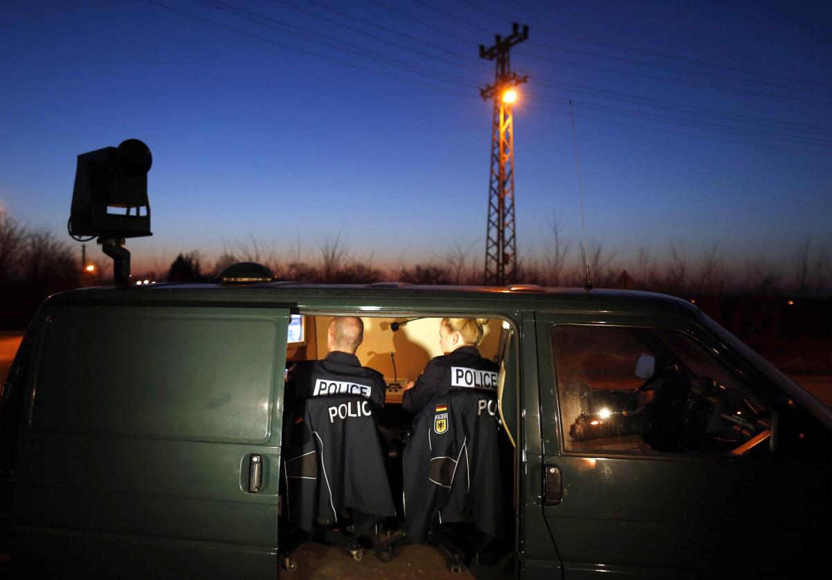 Miembros de la policía fronteriza alemana se sientan en una van mientras revisan una cámara de seguridad que monitorea un tramo de la frontera con Serbia y Hungría en la población de Hajdukovo, a unos 180 kilómetros al norte de Belgrado, Serbia.