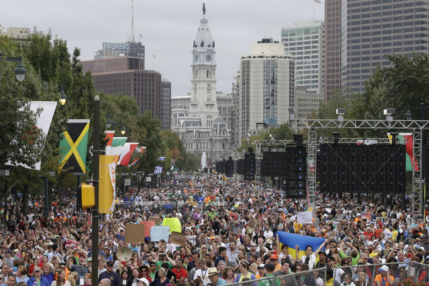 People gathered on the Benjamin Franklin Parkway chant and hold up signs to protest a tent that was erected, blocking their view of Pope Francis before his Mass, Sunday, Sept. 27, 2015, in Philadelphia.
