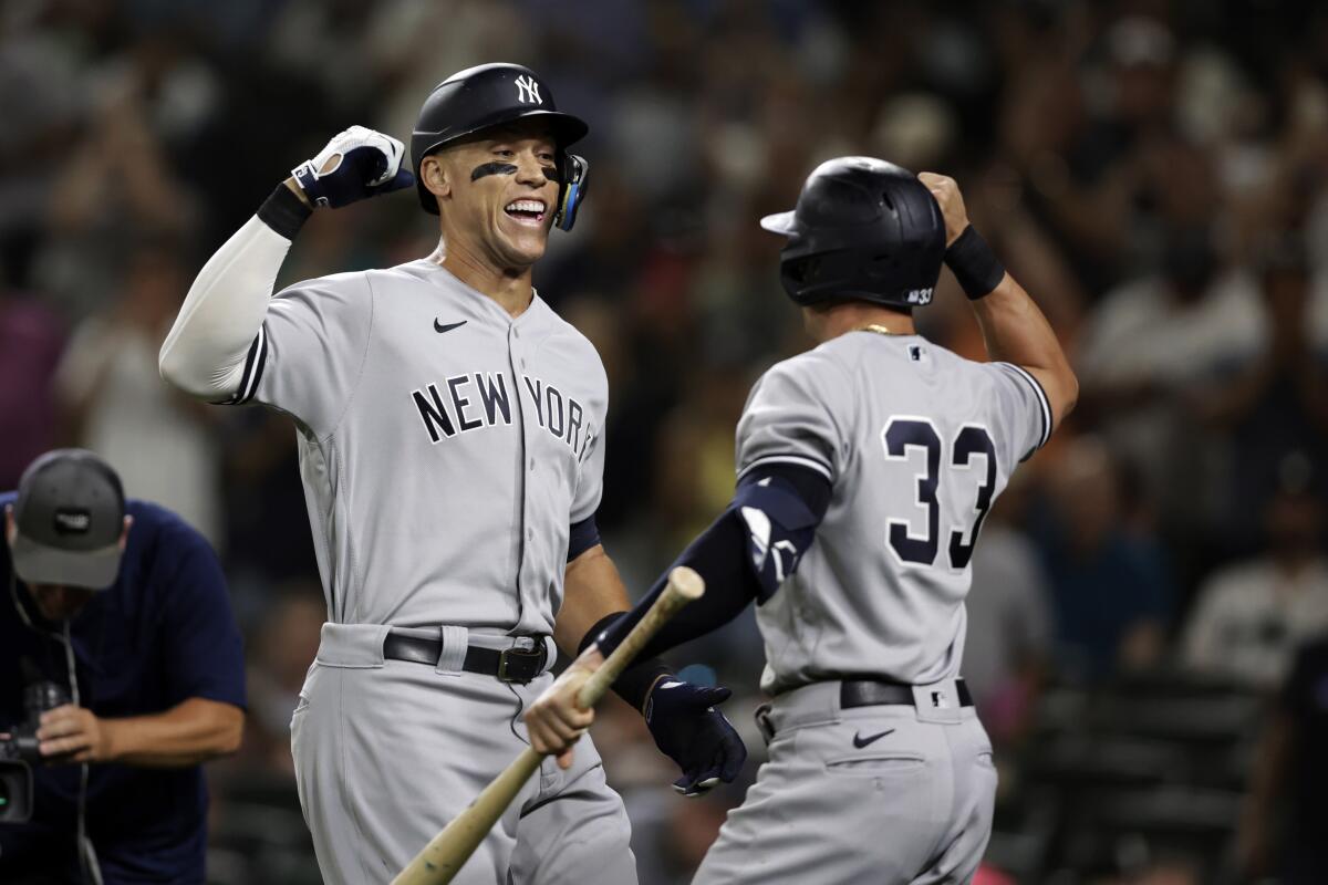 New York Yankees' Aaron Judge celebrates with Tim Locastro after hitting a solo home run on a pitch from Seattle Mariners' Ryan Borucki during the ninth inning of a baseball game, Monday, Aug. 8, 2022, in Seattle. (AP Photo/John Froschauer)