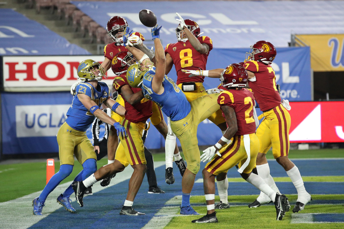 USC players prevent UCLA tight end Greg Dulcich (85) from making a catch on a desperation pass at the end of the game.