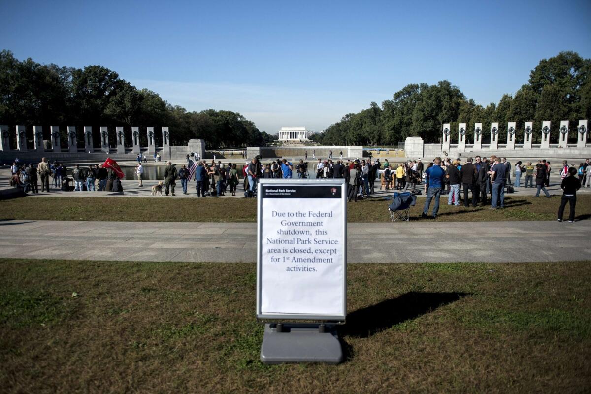 People linger at the World War II Memorial after a rally at the monument on the National Mall in Washington. Activists from several veterans groups gathered to protest the government shutdown and call for resolutions to the budget crisis.