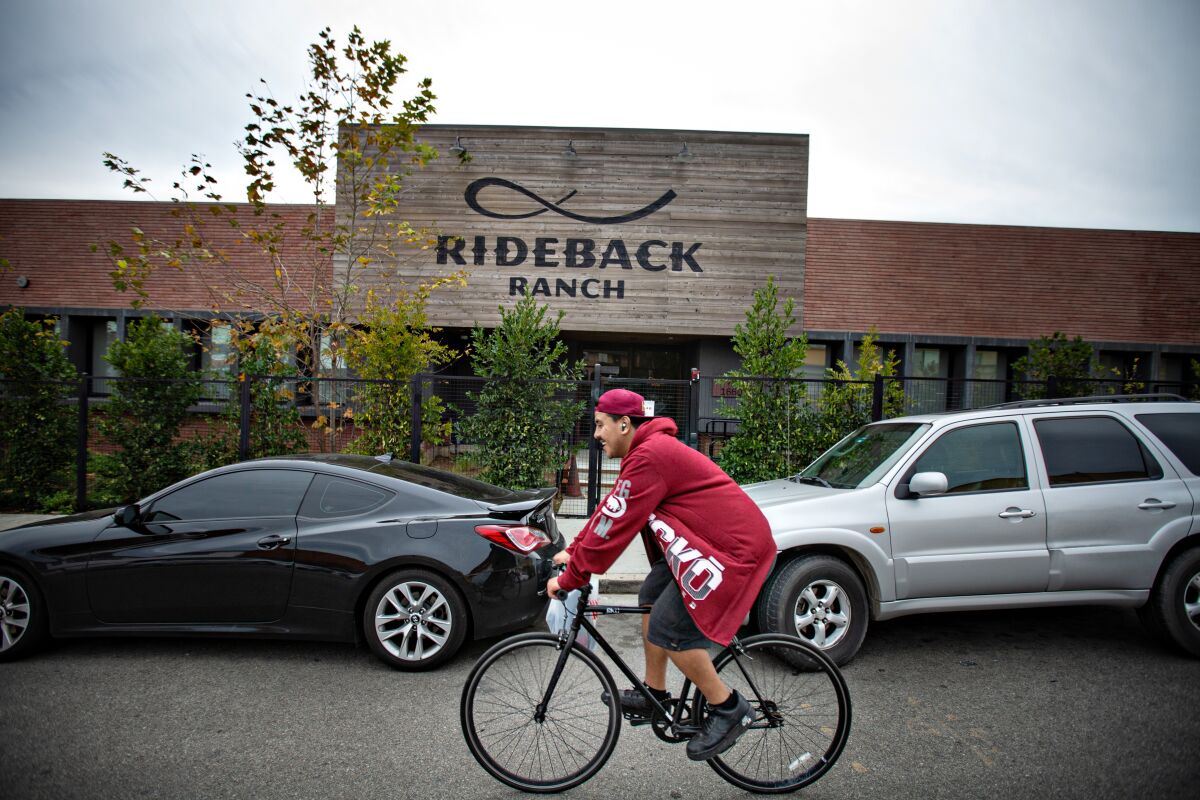 A cyclist passes Rideback Ranch, a communal workspace in Los Angeles. 