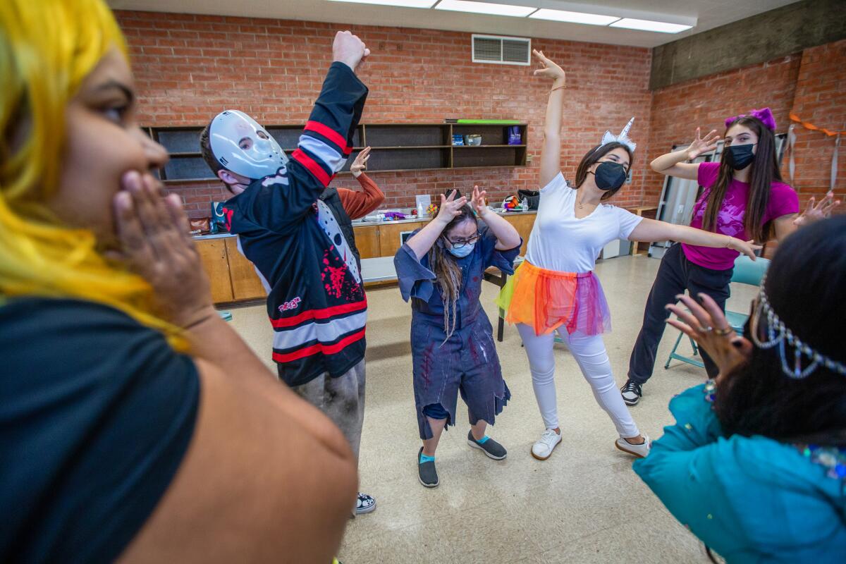 People dance in a line while wearing Halloween costumes.