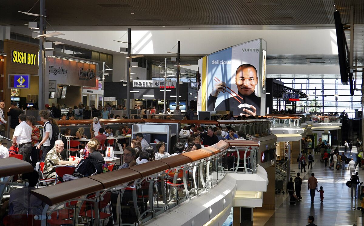 Travelers dine in a food court at LAX. London's Gatwick Airport is reportedly testing "happy meals" with mood-enhancing hormones to see if they improve passengers' travel experience.