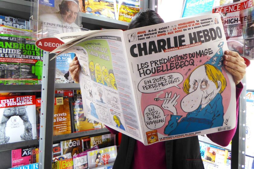 A woman reads the latest issue of the French satirical newspaper Charlie Hebdo at a bookstore in Paris on Jan. 7.
