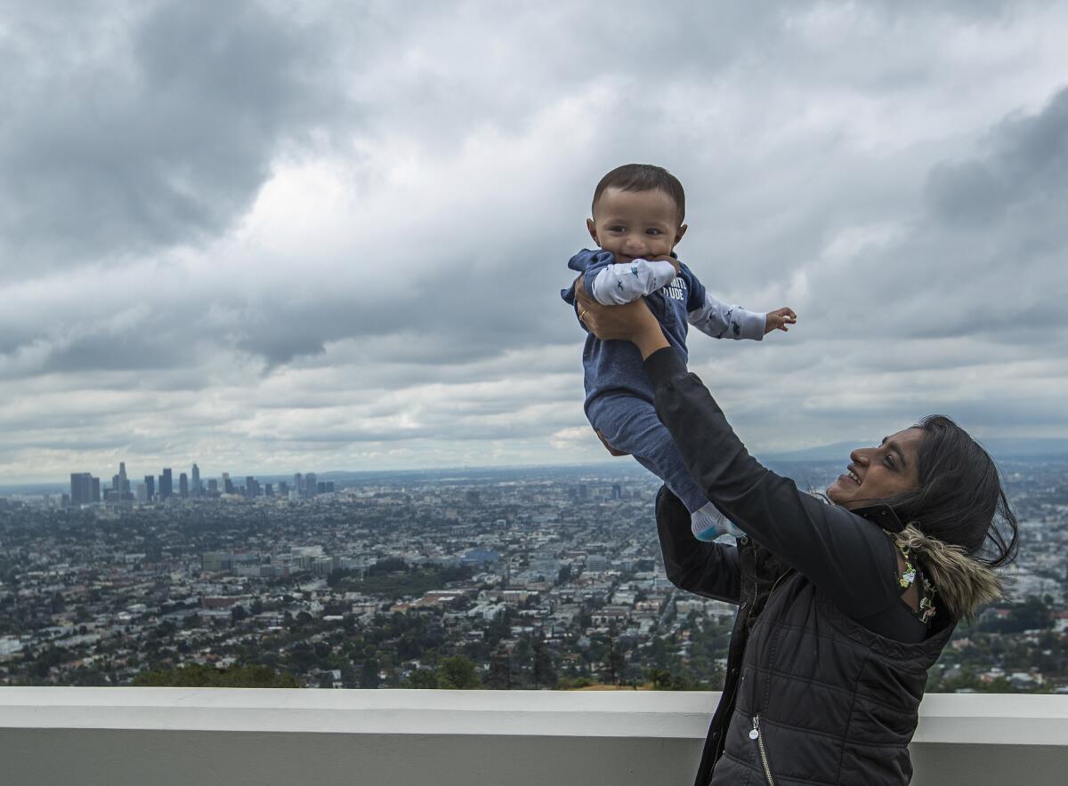 Tejal Patel, 19, takes in the view with her cousin Smit Patil, 8 months, during a visit to the Griffith Observatory on a gloomy, first day of summer, June 21, 2019. T