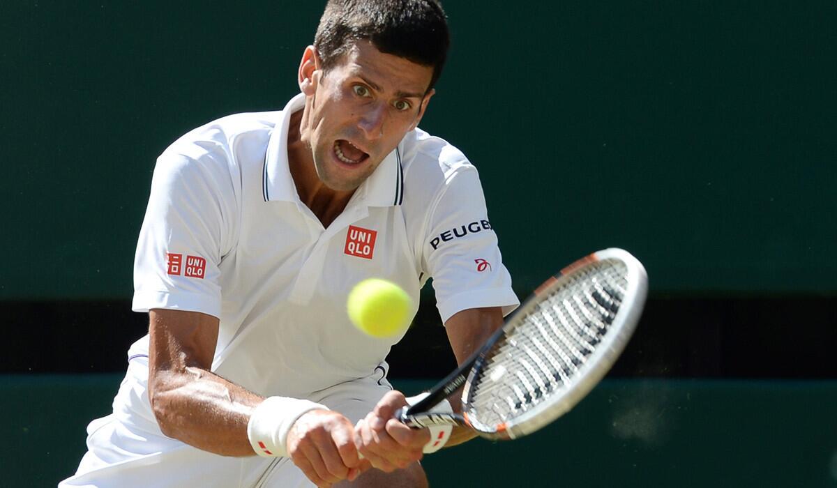 Novak Djokovic returns a shot against Grigor Dimitrov in a four-set victory in the Wimbledon semifinals on Friday.