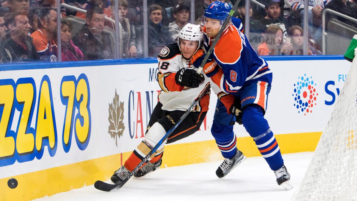 Ducks center Michael Sgarbossa battles Oilers defenseman Griffin Reinhart in a chase for the puck during second period