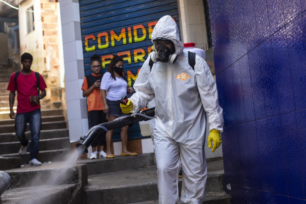 A volunteer sprays disinfectant in an alley.