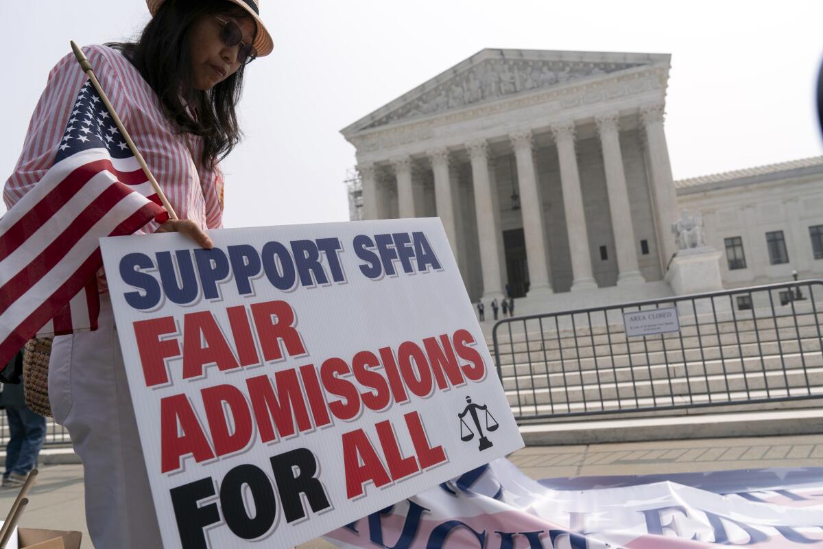 An affirmative action opponent holds a sign  outside the Supreme Court in Washington on June 29.