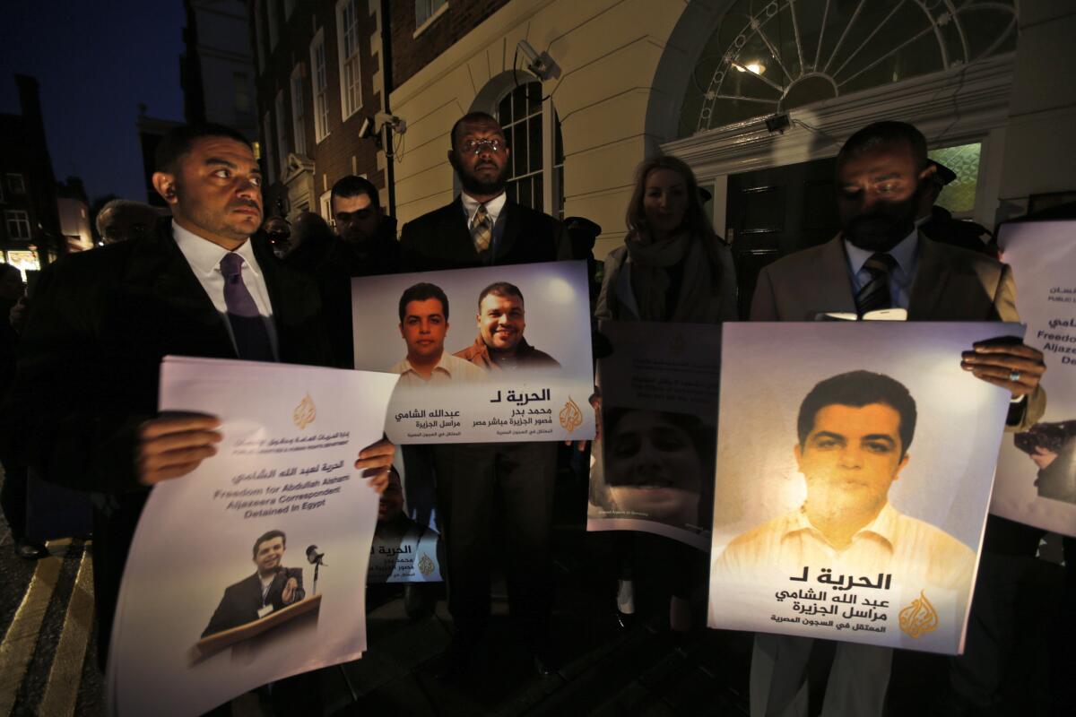 Demonstrators outside the Egyptian Embassy in London hold placards with pictures of Al Jazeera journalists being held by Egyptian authorities.