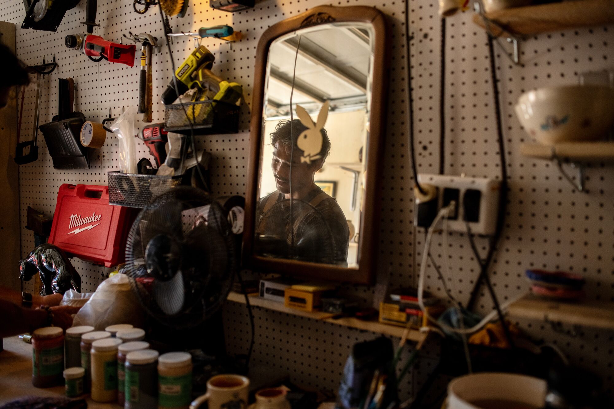 Daniel Dooreck reflected in a mirror in a garage.