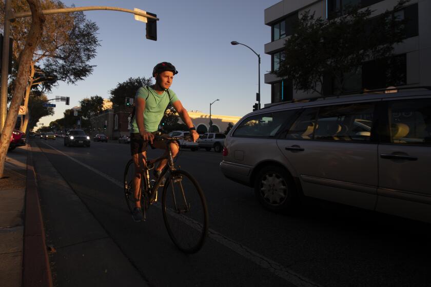 West Hollywood, CA - October 28: A person on a bike rides in the bike lane along Santa Monica Blvd. in West Hollywood at sunset Thursday, Oct. 28, 2021. (Allen J. Schaben / Los Angeles Times)