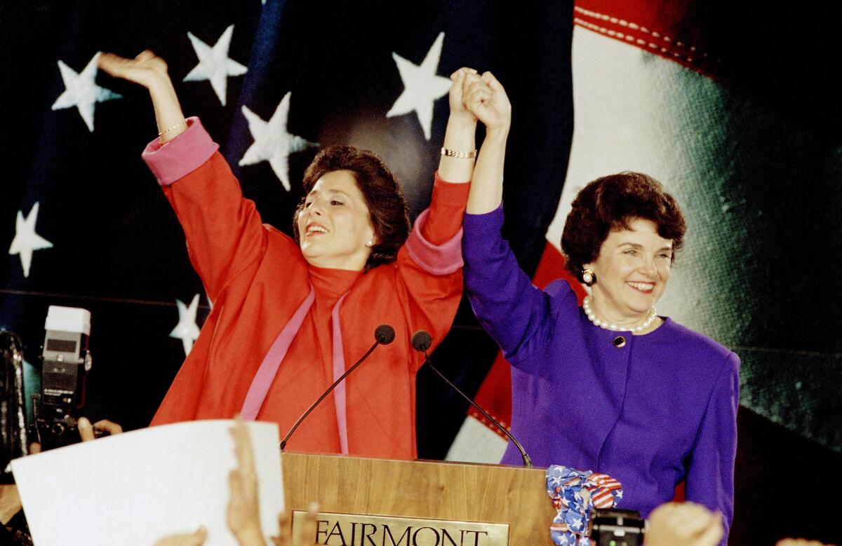 Barbara Boxer, left, and Dianne Feinstein raise their arms in victory and wave to supporters at a 1992 election rally in San Francisco.