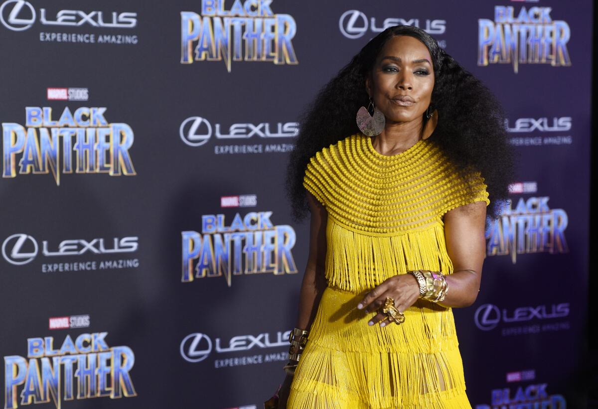 Angela Bassett, who plays Queen Ramonda in Marvel's "Black Panther," arrives at the Jan. 29 premiere at the Dolby Theatre in Hollywood wearing jewelry by Douriean Fletcher, who also created jewelry for the new film.