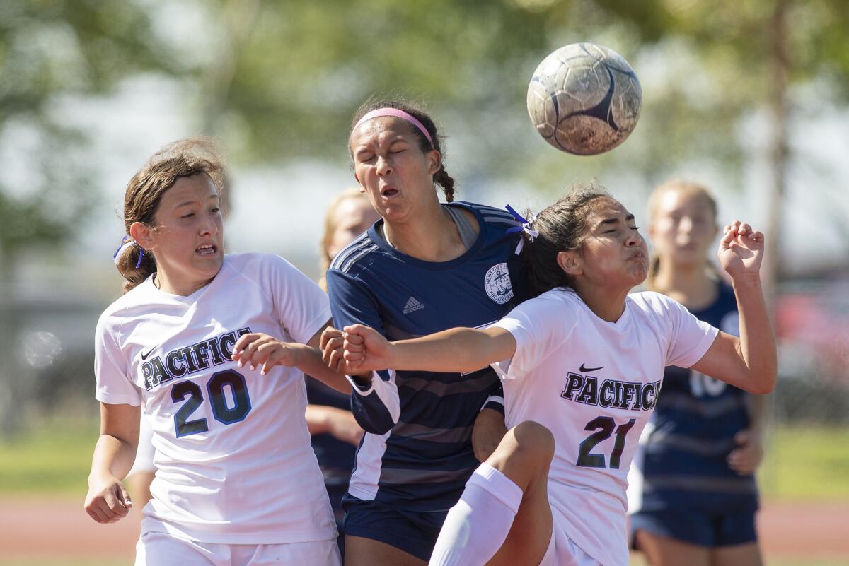 Newport Harbor's Alyssa Sims goes up for a header against Pacifica's Serena Brito, left, and Natalie Oca on Friday.