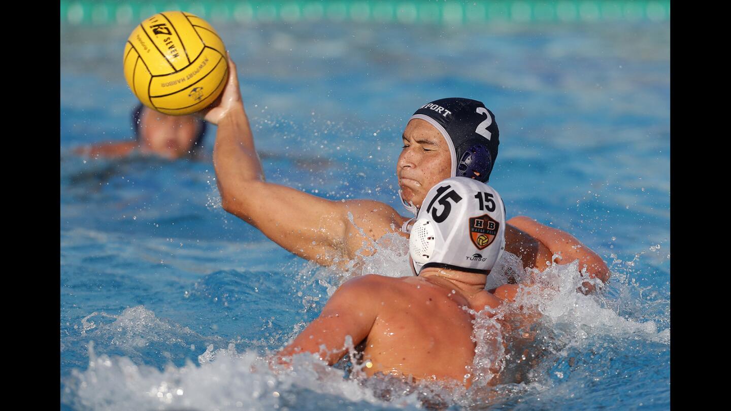 Newport Harbor High's Makoto Kenney (2) scores against Huntington Beach's Chase Dodd (15) during the first half in a Surf League match at Newport Harbor High on Wednesday, Sept. 26.