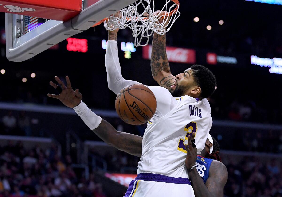 Lakers forward Anthony Davis dunks over Clippers forward Montrezl Harrell during the Lakers' 112-103 win Sunday at Staples Center.