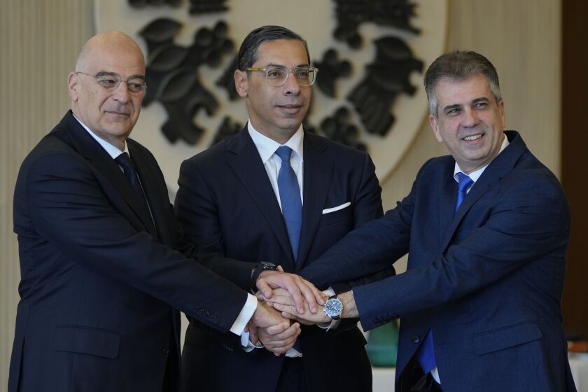 Cyprus Foreign Minister Constantinos Kombos, center, shake hands with his counterparts Israeli counterpart Eli Cohen, right, and Greek Nikos Dendias before their meeting at the Presidential palace in capital Nicosia, Cyprus, on Friday, March 31, 2023. The foreign ministers of Cyprus, Greece and Israel are holding another in a series of high-level meetings between the three countries established to further strengthen blossoming relations founded on the discovery of substantial natural gas deposits in east Mediterranean waters. (AP Photo/Petros Karadjias)