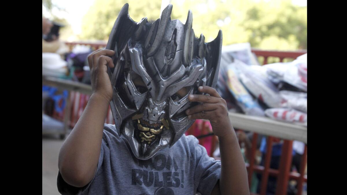 Three-year-old Alexis Hernandez tries on his new Transformer mask at the Mar Vista Family Center in Culver City.