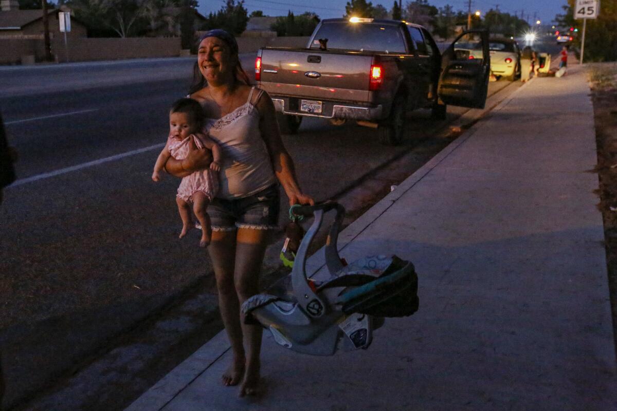 Dawn Inscore flees her Ridgecrest apartment with her infant after Friday's earthquake. (Irfan Khan / Los Angeles Times)