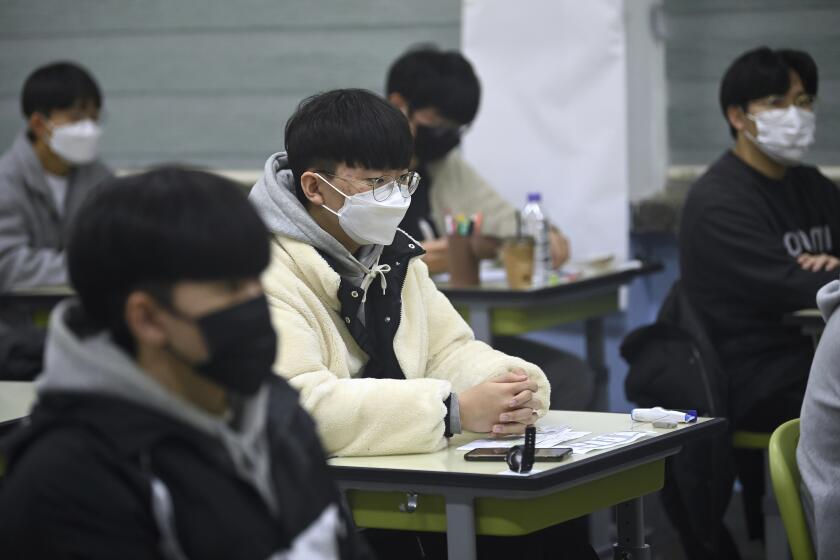 South Korean students wait for the start of their College Scholastic Ability Test in an exam hall at a high school in Seoul Thursday, Nov. 18, 2021. About 510,000 high school seniors and graduates across the country are expected to take the annual highly competitive university entrance exam. (Jung Yeon-je/Pool Photo via AP)