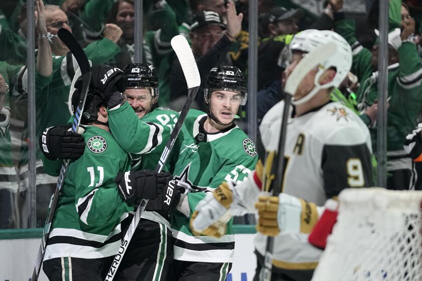 Dallas Stars' Logan Stankoven (11), Evgenii Dadonov, second from left, and Wyatt Johnston (53) celebrate a goal by Dadonov as Vegas Golden Knights' Jack Eichel (9) skates past in the first period in Game 5 of an NHL hockey Stanley Cup first-round playoff series in Dallas, Wednesday, May 1, 2024. (AP Photo/Tony Gutierrez)