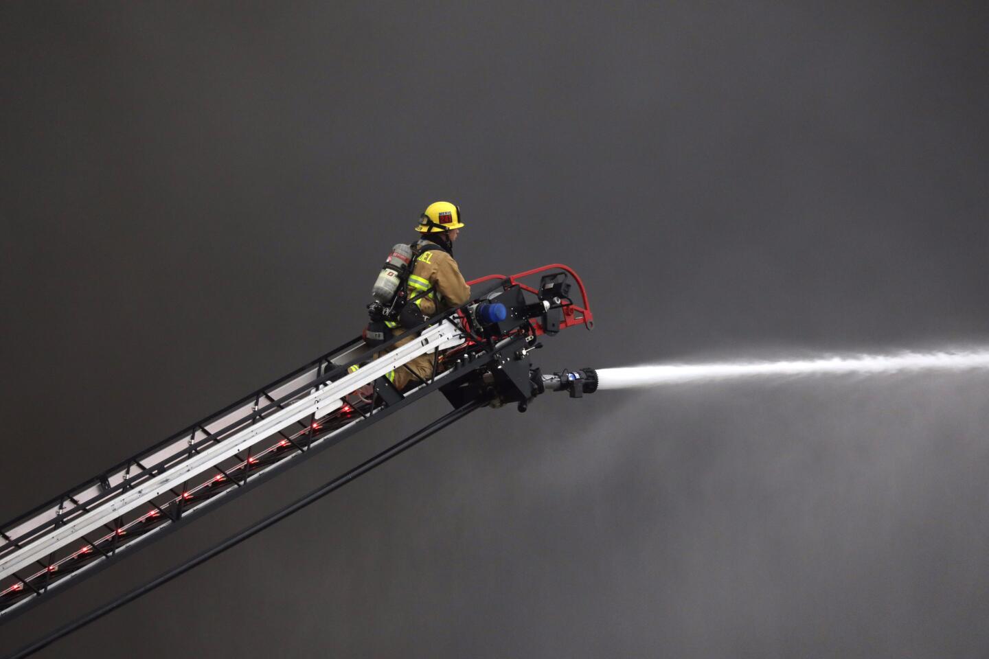 Firefighters battle the fire at a warehouse, which closed the 10 Freeway briefly.