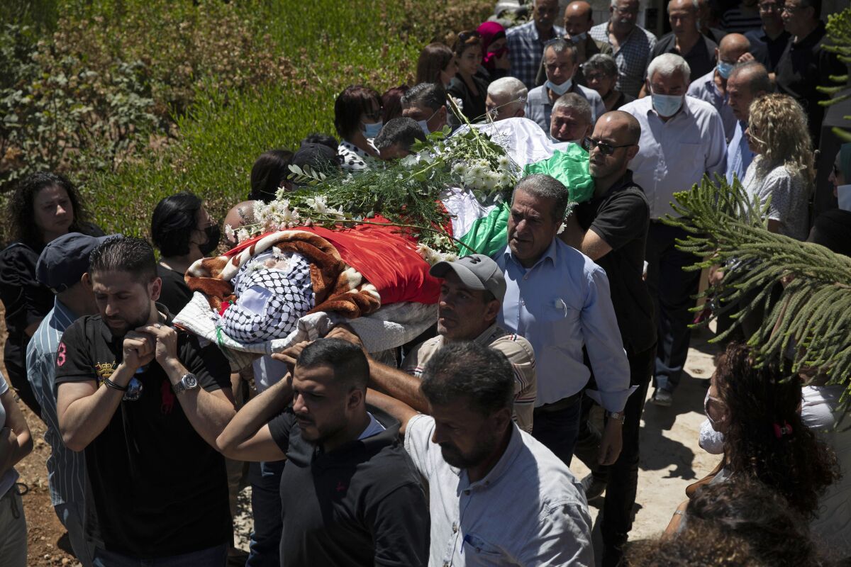 Palestinian mourners carry the body of Suha Jarrar, 30-year-old, daughter of Khalida Jarrar who is a prisoner in an Israeli jail, during her funeral, in the West Bank city of Ramallah, Tuesday, July 13, 2021. Khalida Jarrar, 58, a leading member of the Popular Front for the Liberation of Palestine, has been in and out of Israeli prison in recent years. Palestinian activists and human rights groups urged Israel to allow Jarrar to attend her daughter’s funeral. (AP Photo/Majdi Mohammed)